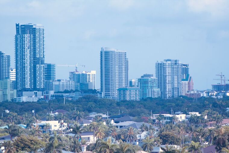 The Miami skyline seen over palm trees and low-rise neighborhoods